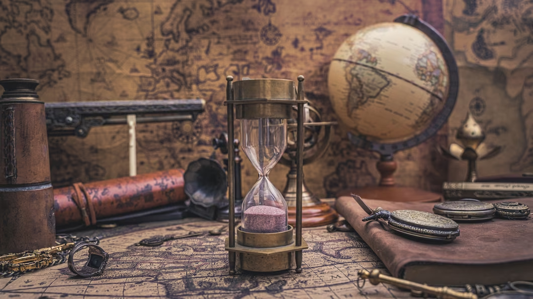 An hourglass surrounded by a map, globe, compass, and historical artifacts