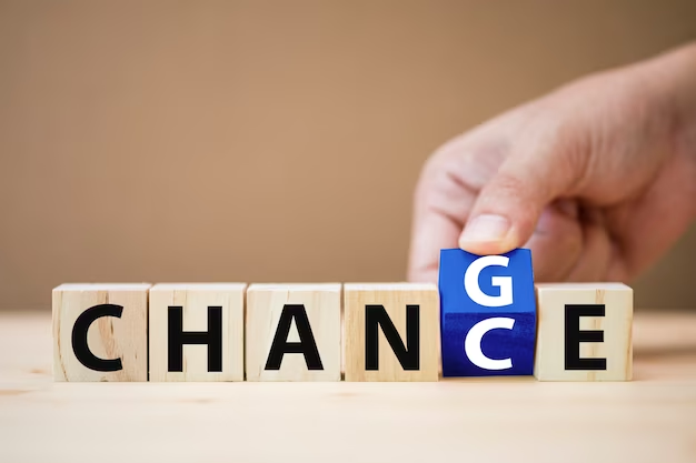 Hand flipping wooden cubes to transition between the words 'change' and 'chance'