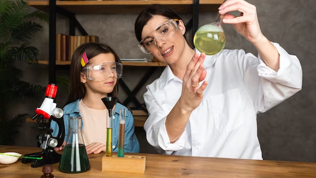 Girl and teacher doing science experiments with microscope