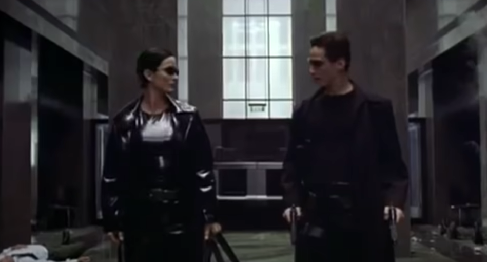 Screenshot of The Matrix movie with two characters in black suits and sunglasses